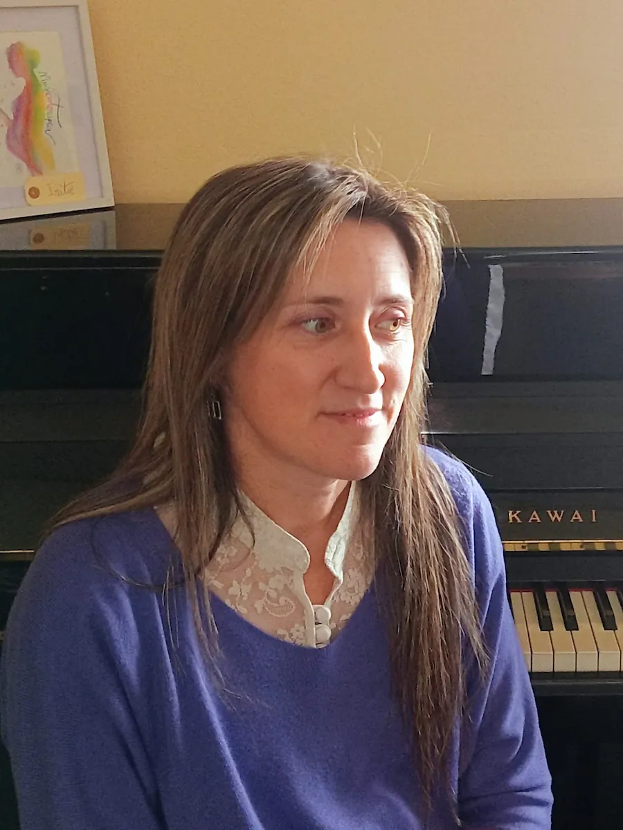 Iratxe Pérez Elizalde, musicoterapeuta de APROMT-CLM junto a un piano
